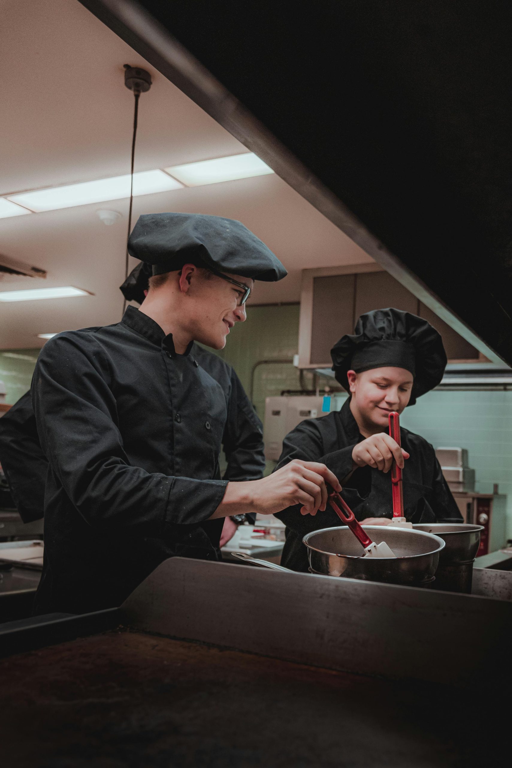Two professional chefs cooking together, laughing and enjoying the culinary experience.